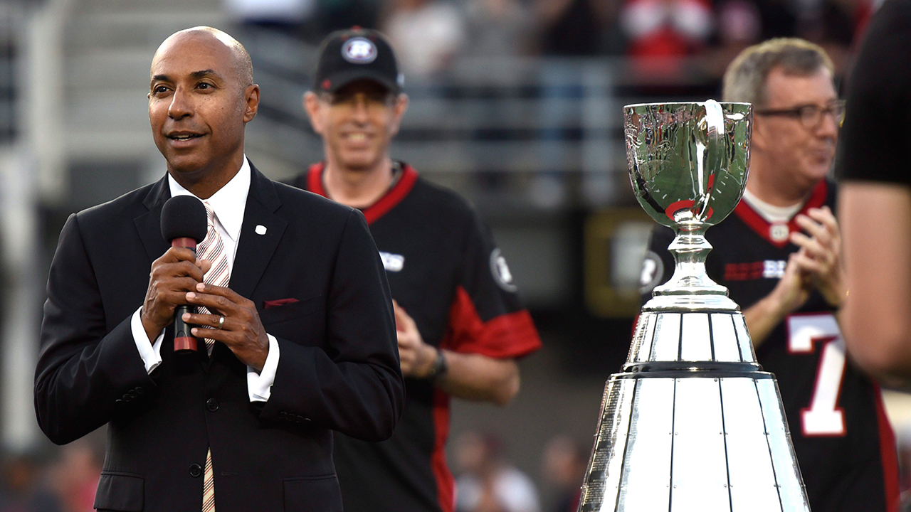 CFL Commissioner Jeffrey Orridge, left, stands beside the Grey Cup as Ottawa is announced as the host of the 2017 Grey Cup championship. (Justin Tang/CP)