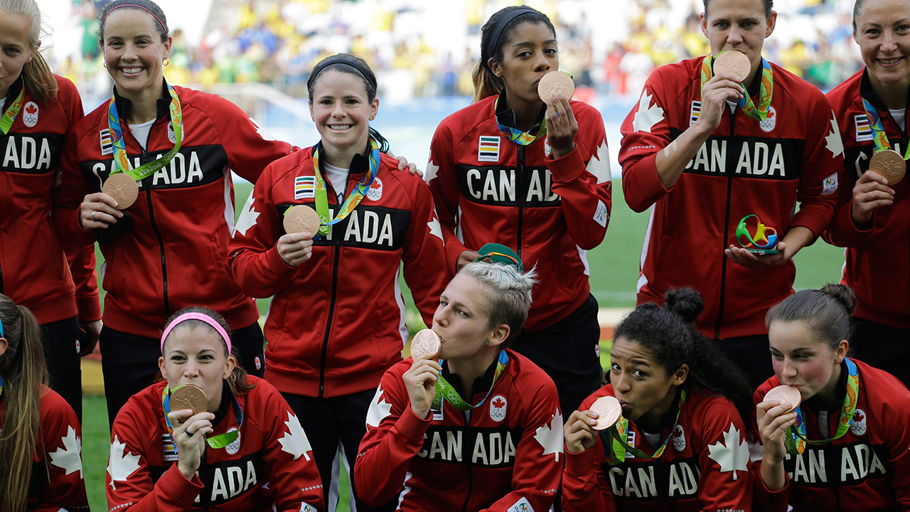 Canada team poses for photos after winning the bronze medal in the women's Olympic football tournament. (Nelson Antoine/AP)