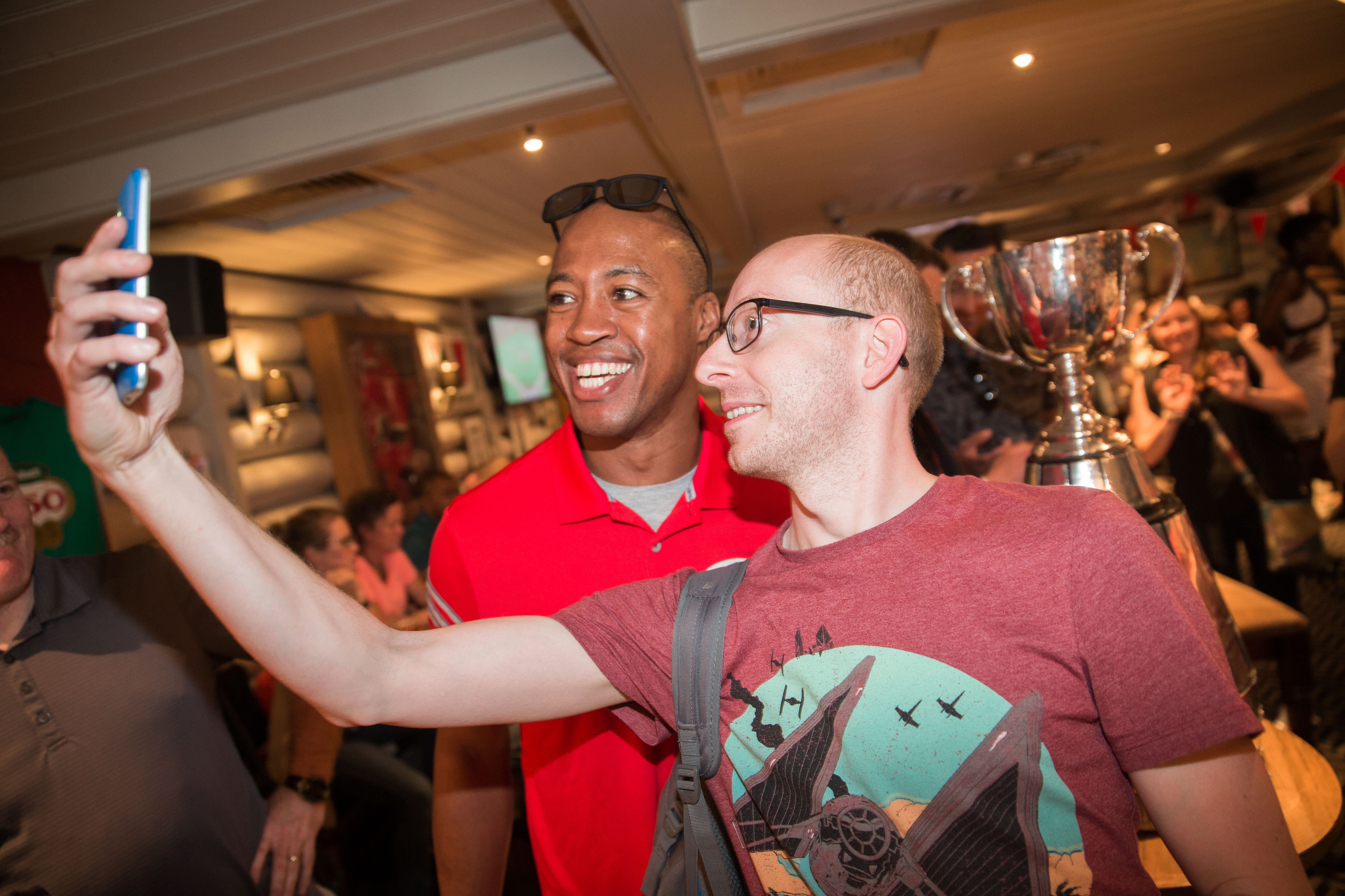 Henry Burris and fans pose for a photo with the Grey Cup inside the Maple Leaf Pub in central London on June 30, 2017. (Photo by Jim Ross/CFL)