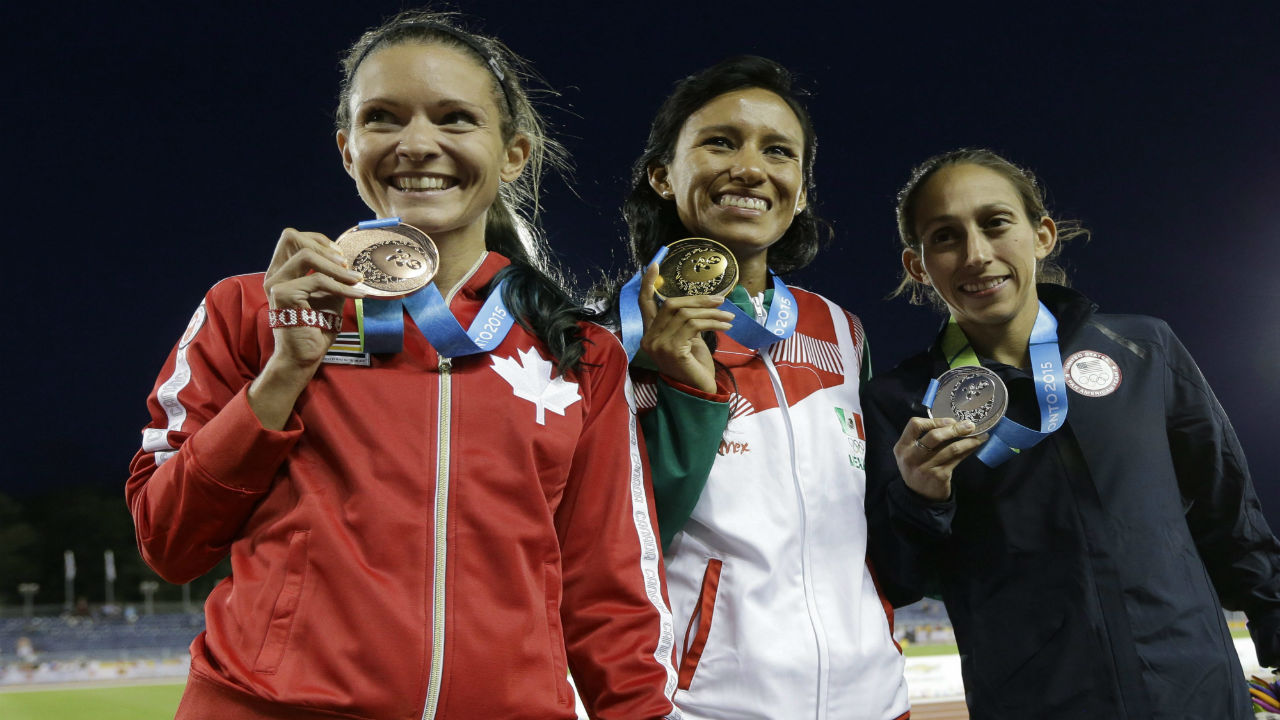 Gold medalist Brenda Flores of Mexico, center, silver medalist Desiree Davila of the United States, right, and bronze medalist Lanni Marchant of Canada pose to photographers during the medal ceremony for the women's 10,000 meter run at the Pan Am Games Thursday, July 23, 2015, in Toronto.