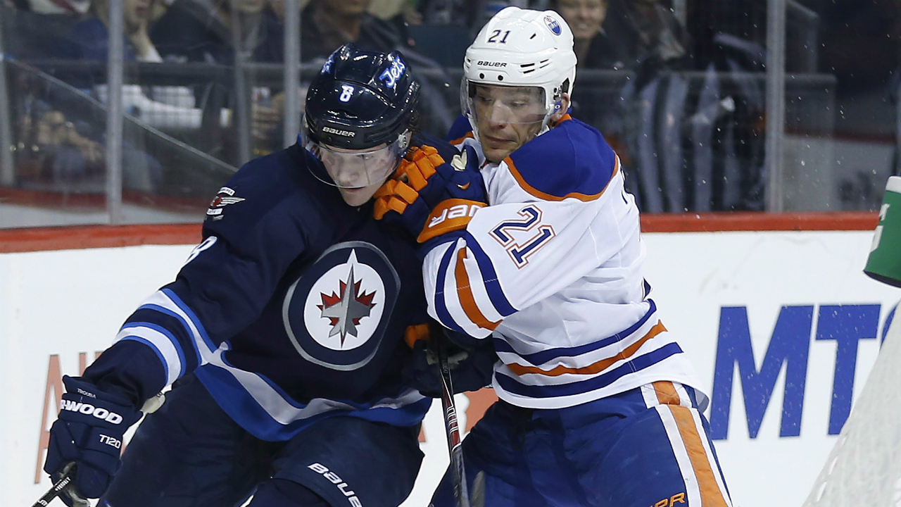 Edmonton Oilers' Andrew Ference (21) and Winnipeg Jets' Jacob Trouba (8) go for the loose puck during second period NHL action in Winnipeg on Wednesday, December 3, 2014. 