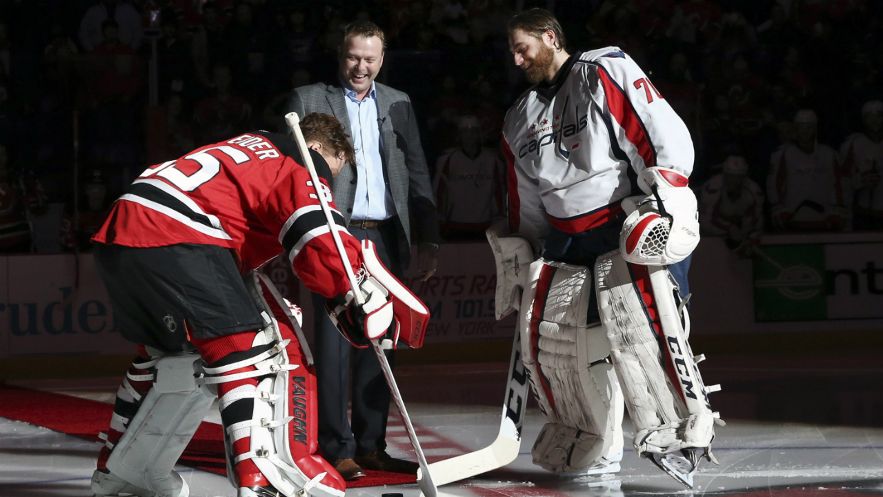 Retired New Jersey Devils goalie Martin Brodeur drops a ceremonial puck between New Jersey Devils goalie Cory Schneider (35) and Washington Capitals goalie Braden Holtby (70) before an NHL hockey game, Saturday, Feb. 6, 2016, in Newark, N.J. (AP Photo/Mel Evans)