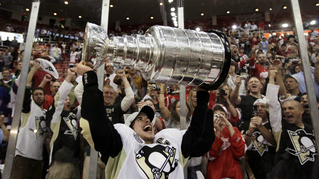 In this June 12, 2009, file photo, Pittsburgh Penguins' captain Sidney Crosby holds up the Stanley Cup after the Penguins beat the Detroit Red Wings 2-1 to win Game 7 of the NHL hockey Stanley Cup finals in Detroit. Wayne Gretzky was "The Great One" and Mario Lemieux was "The Magnificent One."The hockey world is always looking for a new superstar to transcend the sport. Eric Lindros, Sidney Crosby and John Tavares were dubbed "The Next One" as teenagers. (AP Photo/Paul Sancya, File)