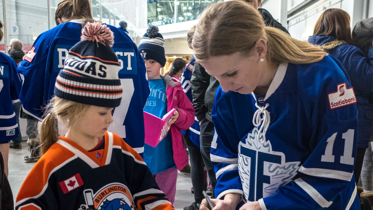 Toronto Furies player Jessica Platt signs an autograph for a young fan.